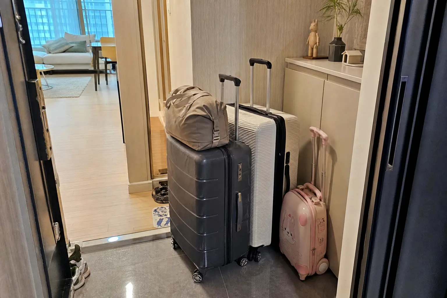 새벽 가족여행 출발 전 현관 앞에 놓인 캐리어와 여행가방